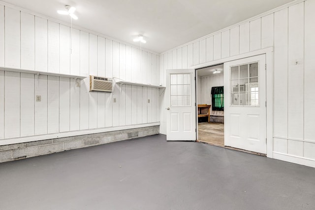 garage with a wall mounted AC and wood walls