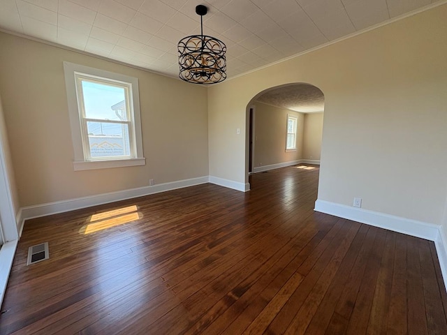 15073 Richmond Rd, Callao, VA 22435 - unfurnished room featuring arched walkways, crown molding, dark wood-style flooring, and a chandelier