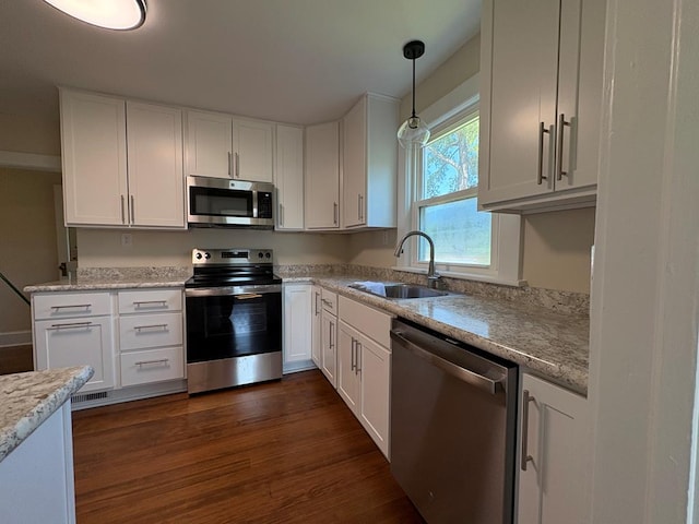 15073 Richmond Rd, Callao, VA 22435 - kitchen featuring appliances with stainless steel finishes, white cabinets, dark wood-style floors, pendant lighting, and light stone counters