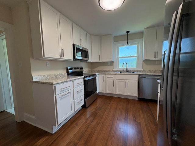 15073 Richmond Rd, Callao, VA 22435 - kitchen with appliances with stainless steel finishes, dark wood-style floors, white cabinetry, and light stone counters