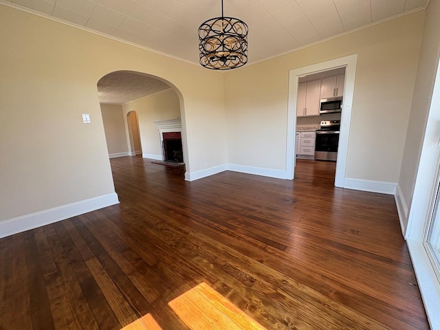 15073 Richmond Rd, Callao, VA 22435 - unfurnished room featuring ornamental molding, arched walkways, dark wood-style floors, a chandelier, and a fireplace