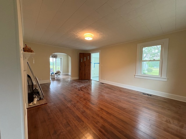 15073 Richmond Rd, Callao, VA 22435 - empty room featuring arched walkways, healthy amount of natural light, and dark wood-type flooring