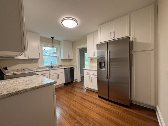 15073 Richmond Rd, Callao, VA 22435 - kitchen with stainless steel appliances, dark wood-style floors, white cabinets, decorative light fixtures, and light stone countertops
