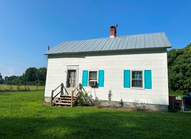 back of property featuring cooling unit and a lawn