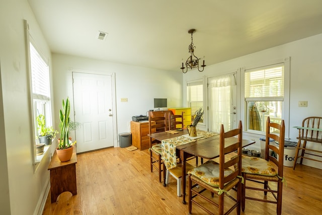 dining space featuring a chandelier and light hardwood / wood-style flooring