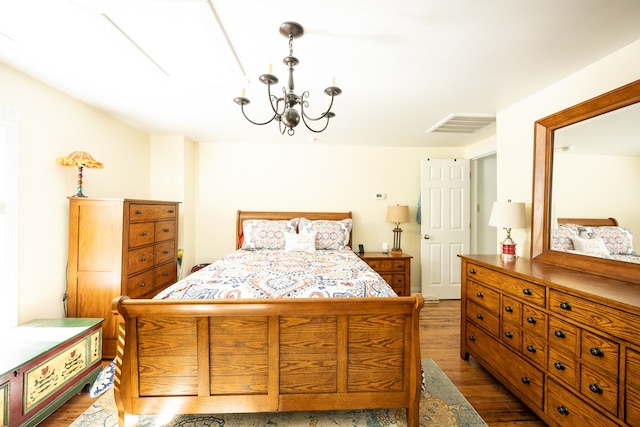 bedroom featuring a chandelier and dark wood-type flooring