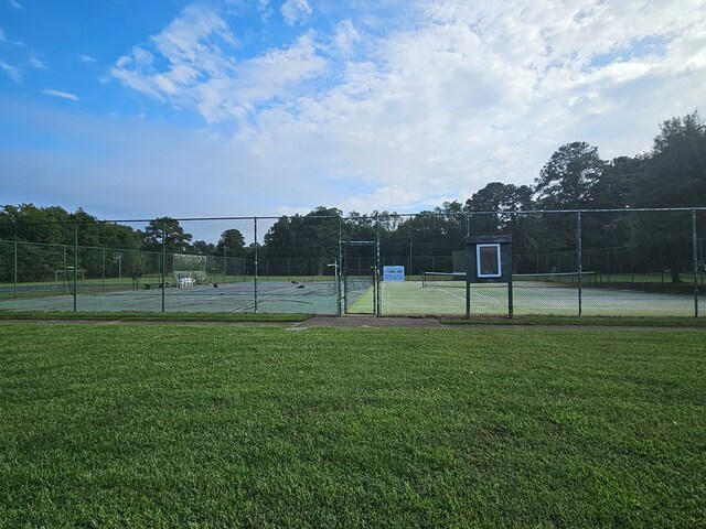 view of sport court featuring a yard and fence