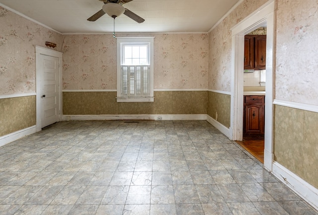 empty room featuring ceiling fan and ornamental molding