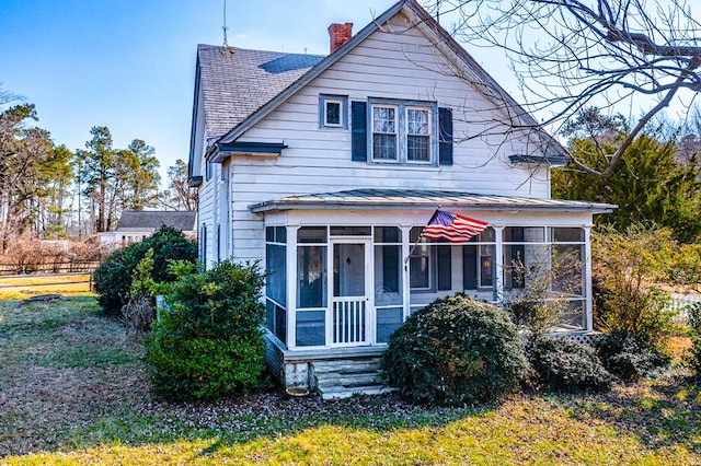 view of front of home featuring a sunroom and a front yard