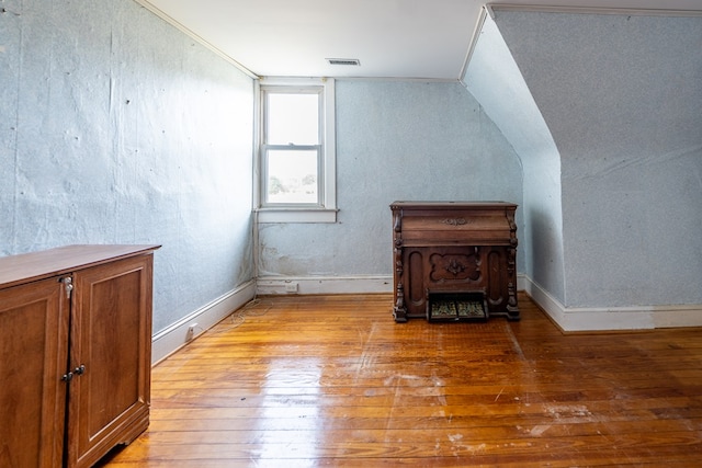 bonus room with lofted ceiling and light wood-type flooring