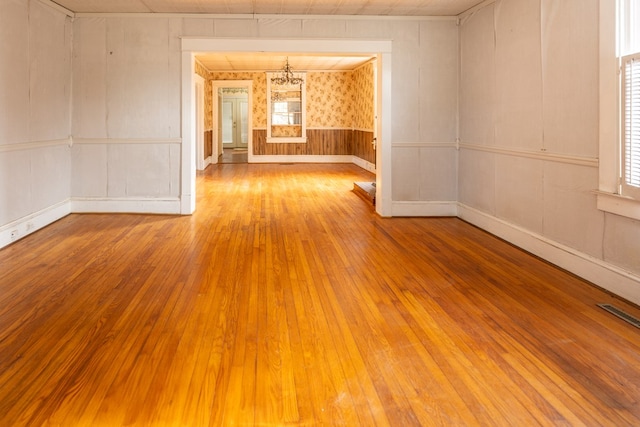 empty room with an inviting chandelier and light wood-type flooring