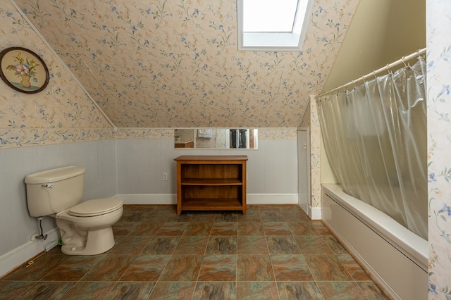 bathroom featuring shower / bath combination with curtain, toilet, and lofted ceiling with skylight