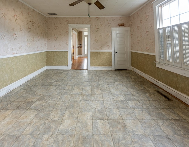 empty room featuring ornamental molding and ceiling fan