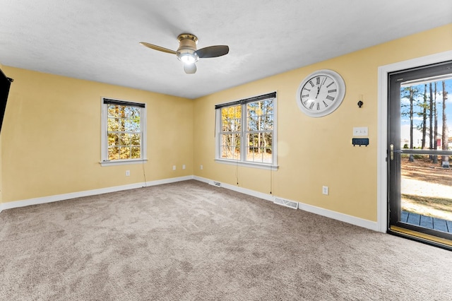 carpeted spare room featuring ceiling fan