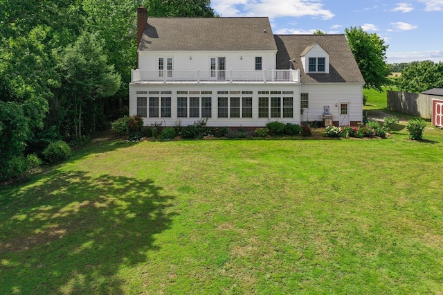 325 Cat Point Dr, Warsaw, VA 22572 - rear view of property with a balcony, a sunroom, a chimney, a yard, and an outdoor structure