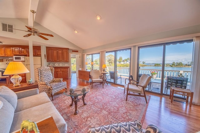 181 Cross St, Urbanna, VA 23175 - living room featuring beam ceiling, light wood finished floors, healthy amount of natural light, high vaulted ceiling, and a water view