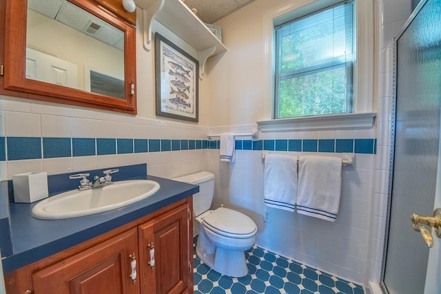 181 Cross St, Urbanna, VA 23175 - full bath featuring vanity, a shower with shower door, tile walls, and a wainscoted wall