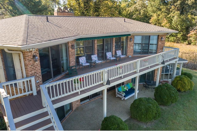 181 Cross St, Urbanna, VA 23175 - back of property with brick siding, a deck, a chimney, a patio, and a shingled roof
