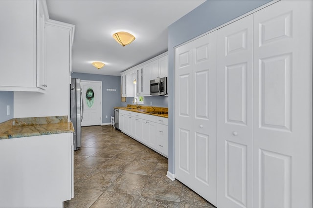 1198 Knights Landing Dr, Heathsville, VA 22473 - kitchen featuring appliances with stainless steel finishes, white cabinetry, a sink, and baseboards