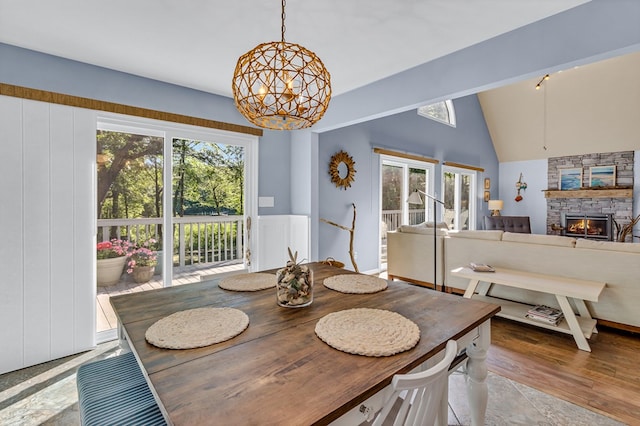 1198 Knights Landing Dr, Heathsville, VA 22473 - dining room featuring a chandelier, healthy amount of natural light, a stone fireplace, vaulted ceiling, and wood finished floors