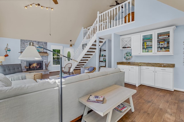 1198 Knights Landing Dr, Heathsville, VA 22473 - living room with high vaulted ceiling, dark wood finished floors, a stone fireplace, ceiling fan, and stairway