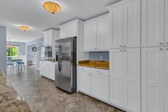1198 Knights Landing Dr, Heathsville, VA 22473 - kitchen with appliances with stainless steel finishes, white cabinets, light stone counters, and stone finish floors