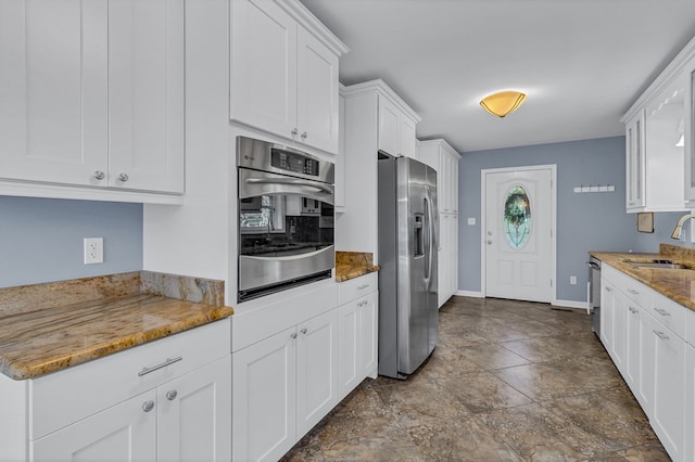 1198 Knights Landing Dr, Heathsville, VA 22473 - kitchen with stainless steel appliances, a sink, white cabinetry, light stone countertops, and baseboards