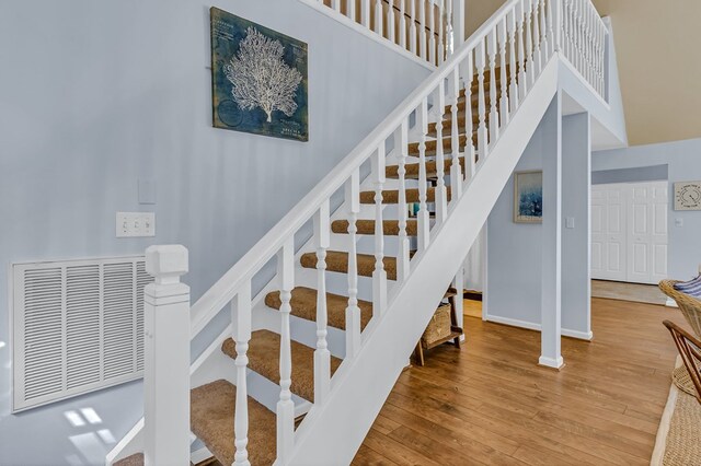 1198 Knights Landing Dr, Heathsville, VA 22473 - stairs with hardwood / wood-style floors, baseboards, and a towering ceiling