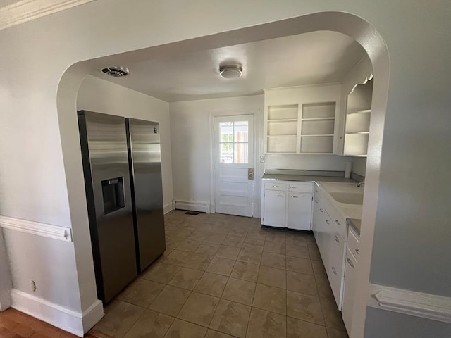 kitchen with white cabinets, stainless steel fridge, tile patterned flooring, and sink