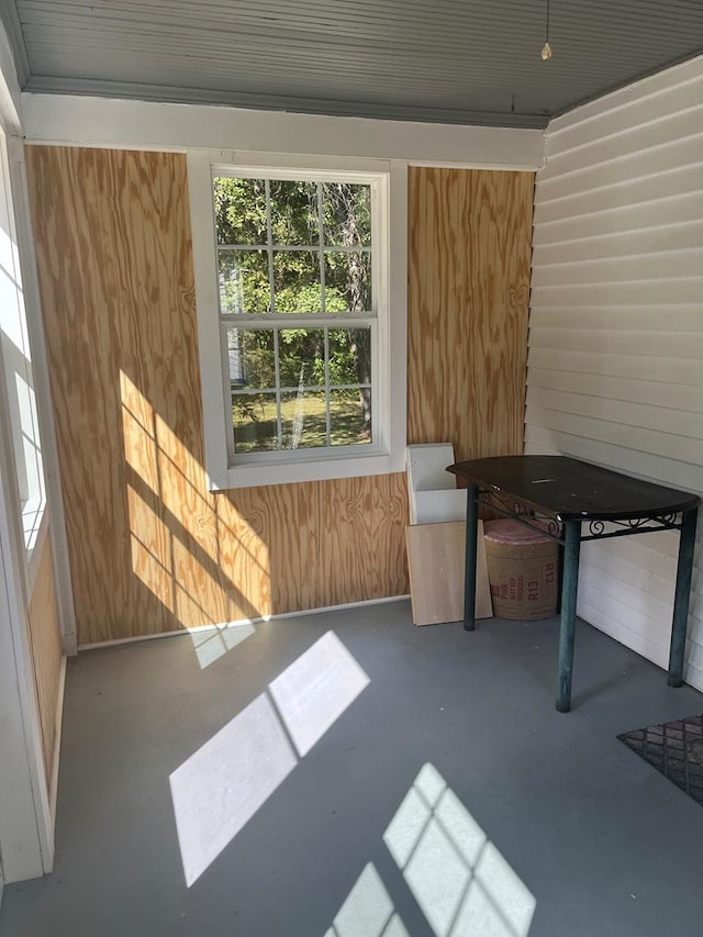 miscellaneous room with wood walls and concrete flooring