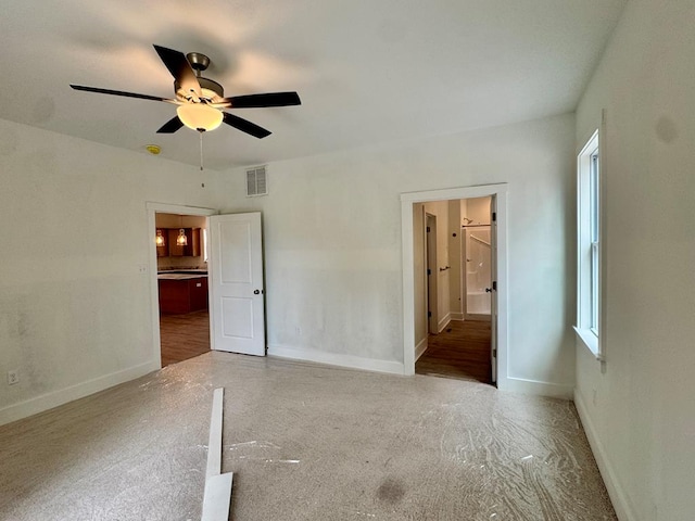 unfurnished bedroom with a ceiling fan, ensuite bath, baseboards, and visible vents