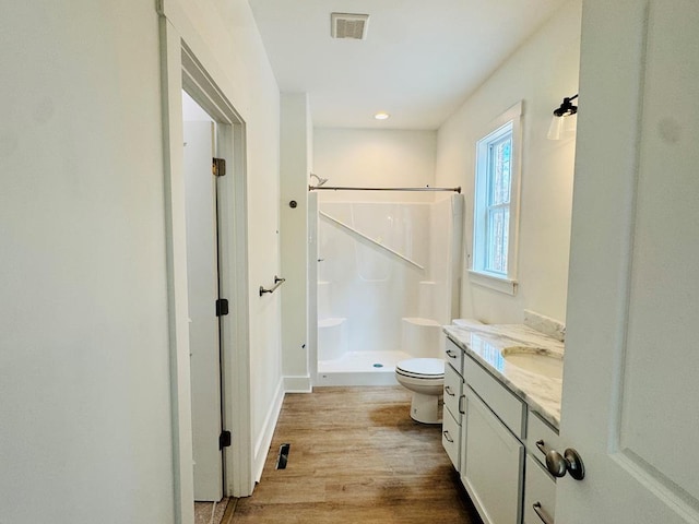 full bath featuring visible vents, toilet, a stall shower, wood finished floors, and vanity