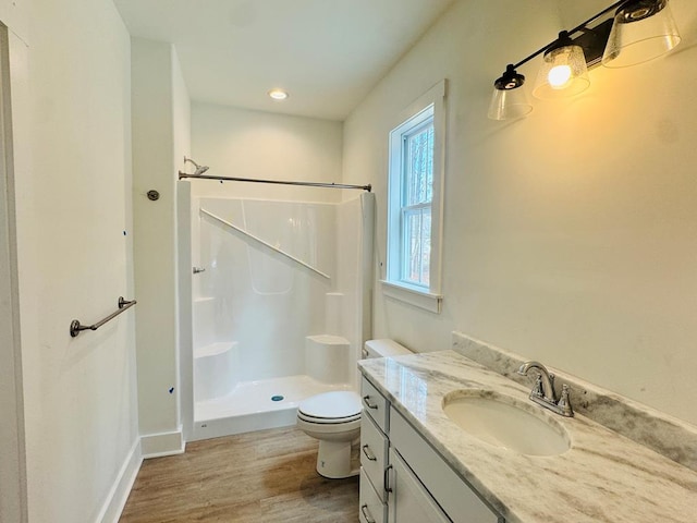 full bath with baseboards, walk in shower, toilet, wood finished floors, and vanity