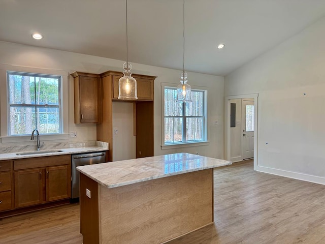 kitchen featuring lofted ceiling, a sink, light wood-style floors, dishwasher, and brown cabinets