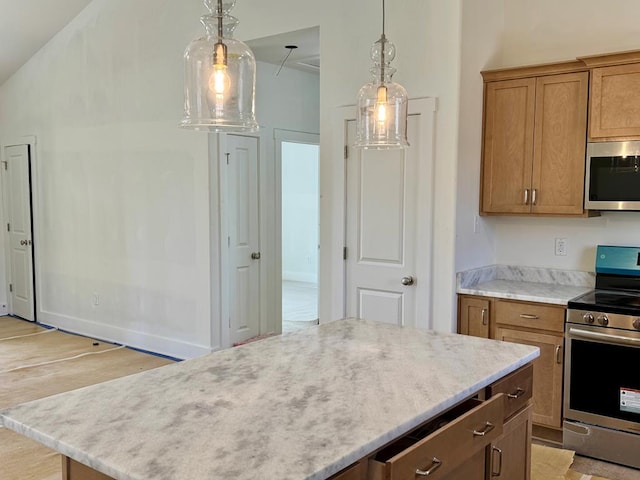 kitchen featuring light wood finished floors, hanging light fixtures, appliances with stainless steel finishes, brown cabinets, and a center island