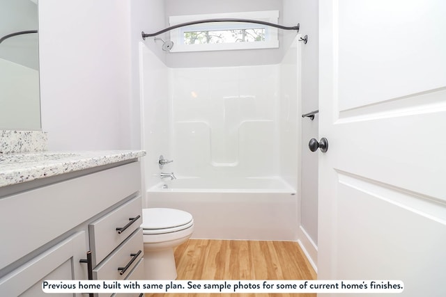 full bathroom featuring hardwood / wood-style floors, vanity, toilet, and shower / tub combination