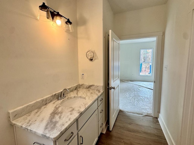 bathroom with vanity, baseboards, and wood finished floors