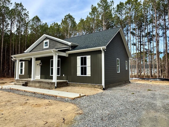 view of front of house featuring a porch, driveway, and roof with shingles