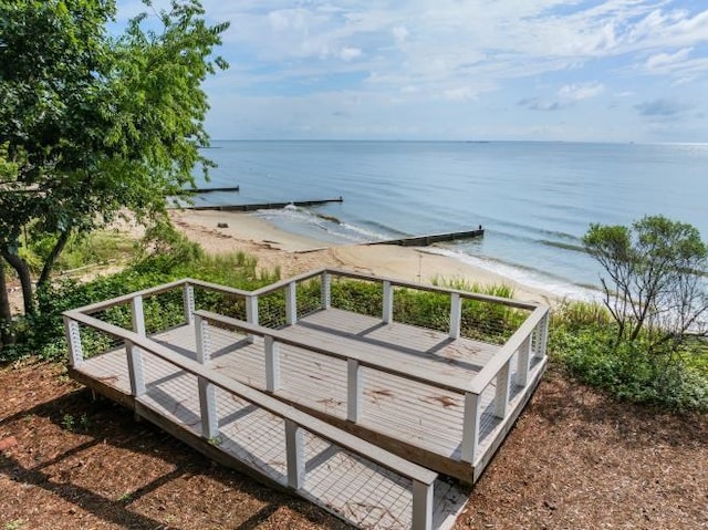 property view of water featuring a dock and a beach view