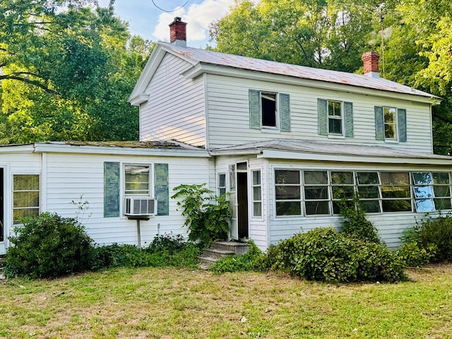 view of front of home featuring cooling unit and a front yard