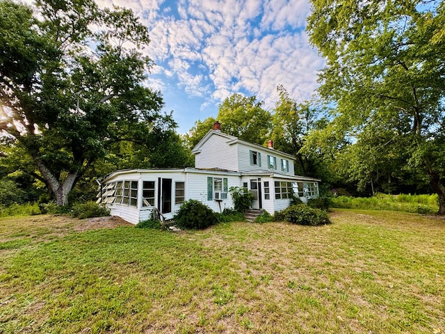 rear view of house featuring a lawn