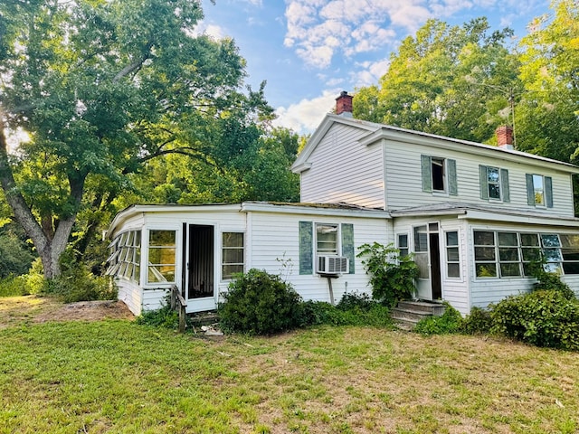 back of property featuring a lawn and a sunroom