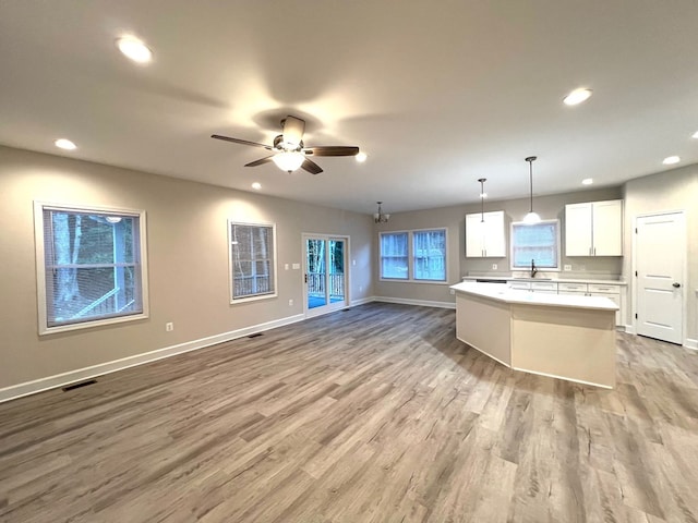 94 Dingley Rd, Va, VA 22520 - kitchen with light wood-style flooring, open floor plan, a center island, white cabinets, and recessed lighting