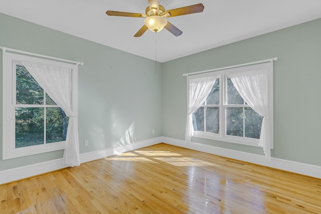 empty room with ceiling fan and light hardwood / wood-style flooring