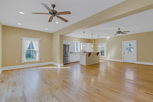 unfurnished living room with ceiling fan and light wood-type flooring