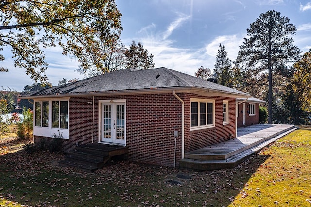 rear view of property featuring french doors and a lawn