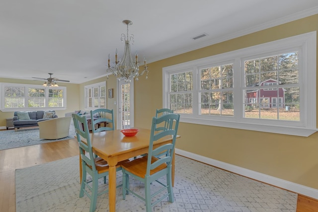 dining room featuring ceiling fan with notable chandelier, light hardwood / wood-style floors, and ornamental molding