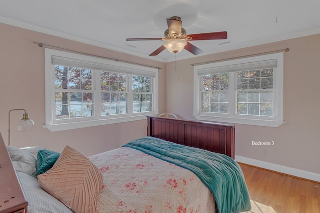 bedroom featuring ceiling fan, wood-type flooring, and crown molding