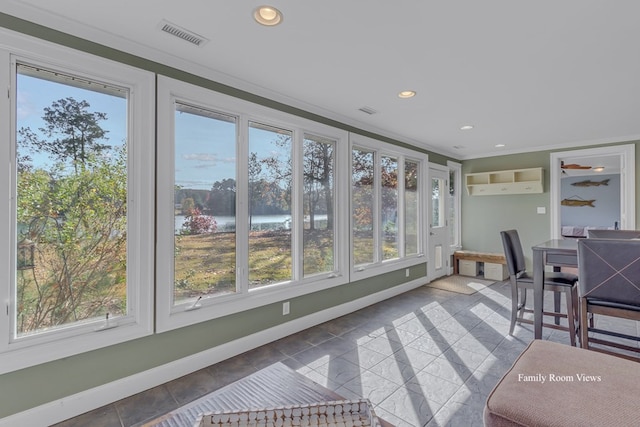 sunroom featuring a wall mounted air conditioner and a water view