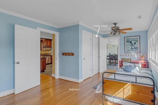 bedroom featuring light hardwood / wood-style flooring, ceiling fan, and crown molding